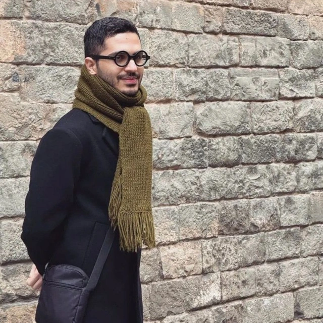 Sena Valiani standing against a stone wall